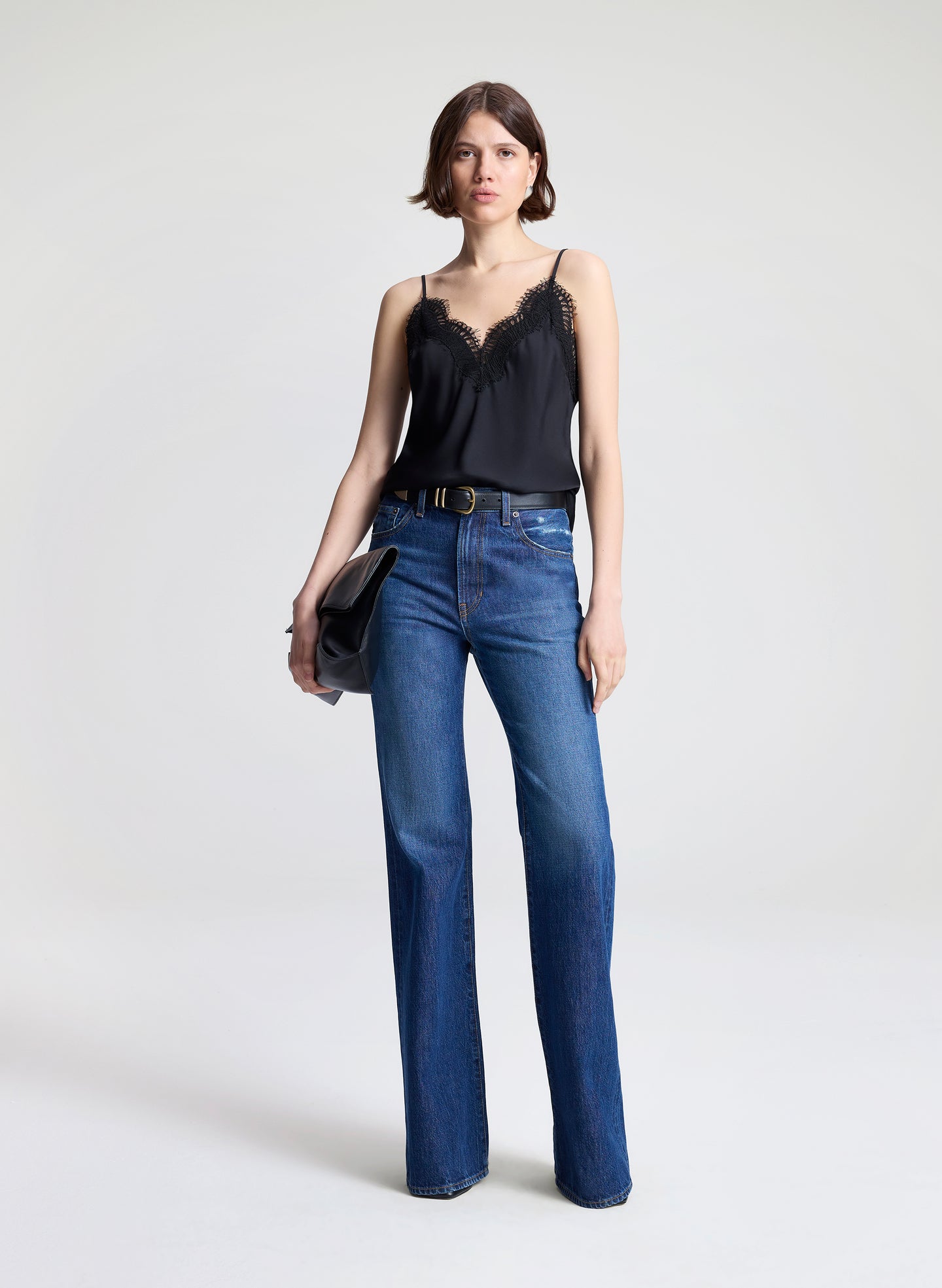 woman wearing black lace camisole and medium blue denim jeans