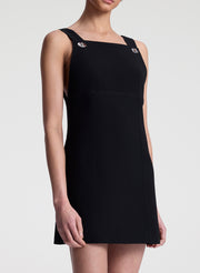 Black sleeveless dress worn by a model on a white background