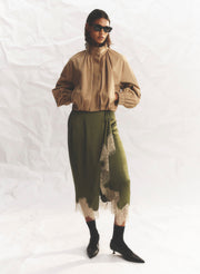 woman wearing green skirt and tan jacket