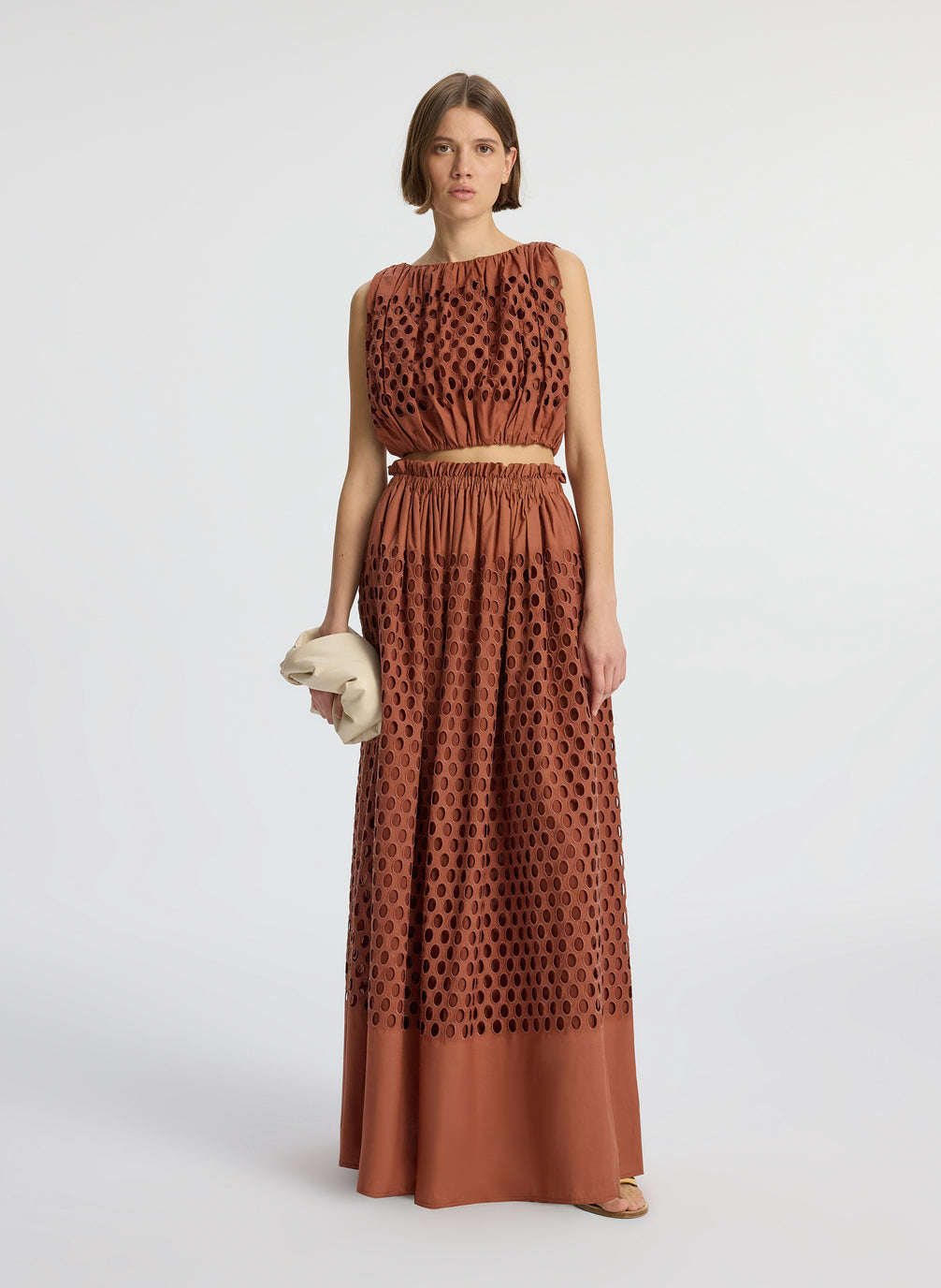 front view of woman wearing brown sleeveless top and matching maxi skirt