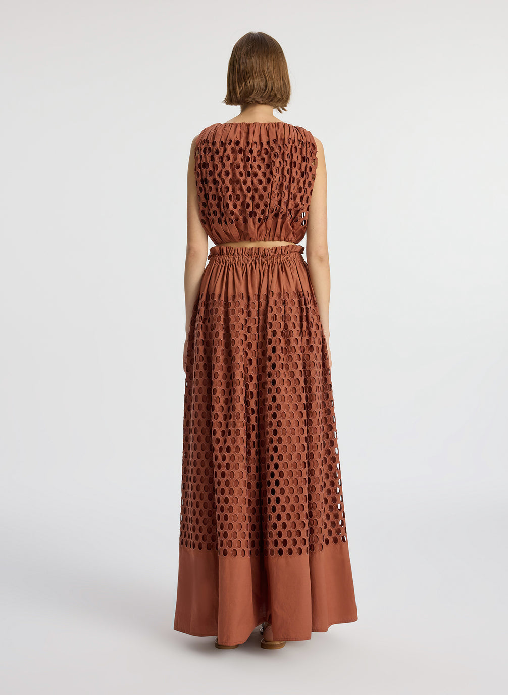back view of woman wearing brown sleeveless top and matching maxi skirt