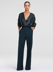 woman wearing green satin top with green wide leg trousers