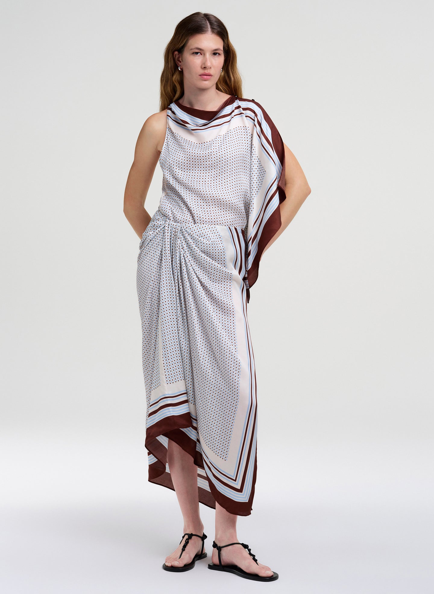 Woman wearing a sleeveless top with matching midi skirt with a pattern on a white background