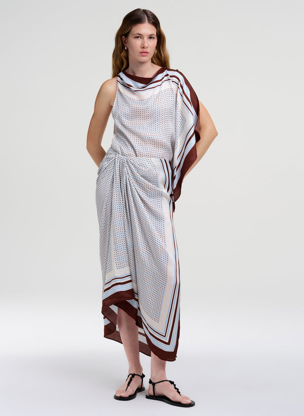 Woman wearing a sleeveless top with matching midi skirt with a pattern on a white background