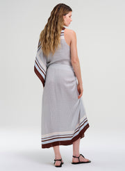 Woman wearing a sleeveless top with a patterned design and matching midi skirt on a white background