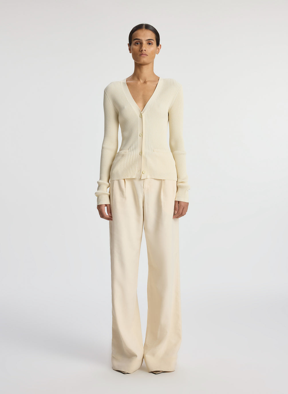 front view of woman wearing cream cardigan and beige pants
