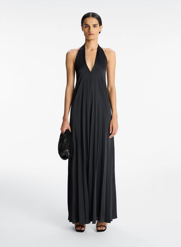 front view of woman wearing black satin pleated halter jumpsuit