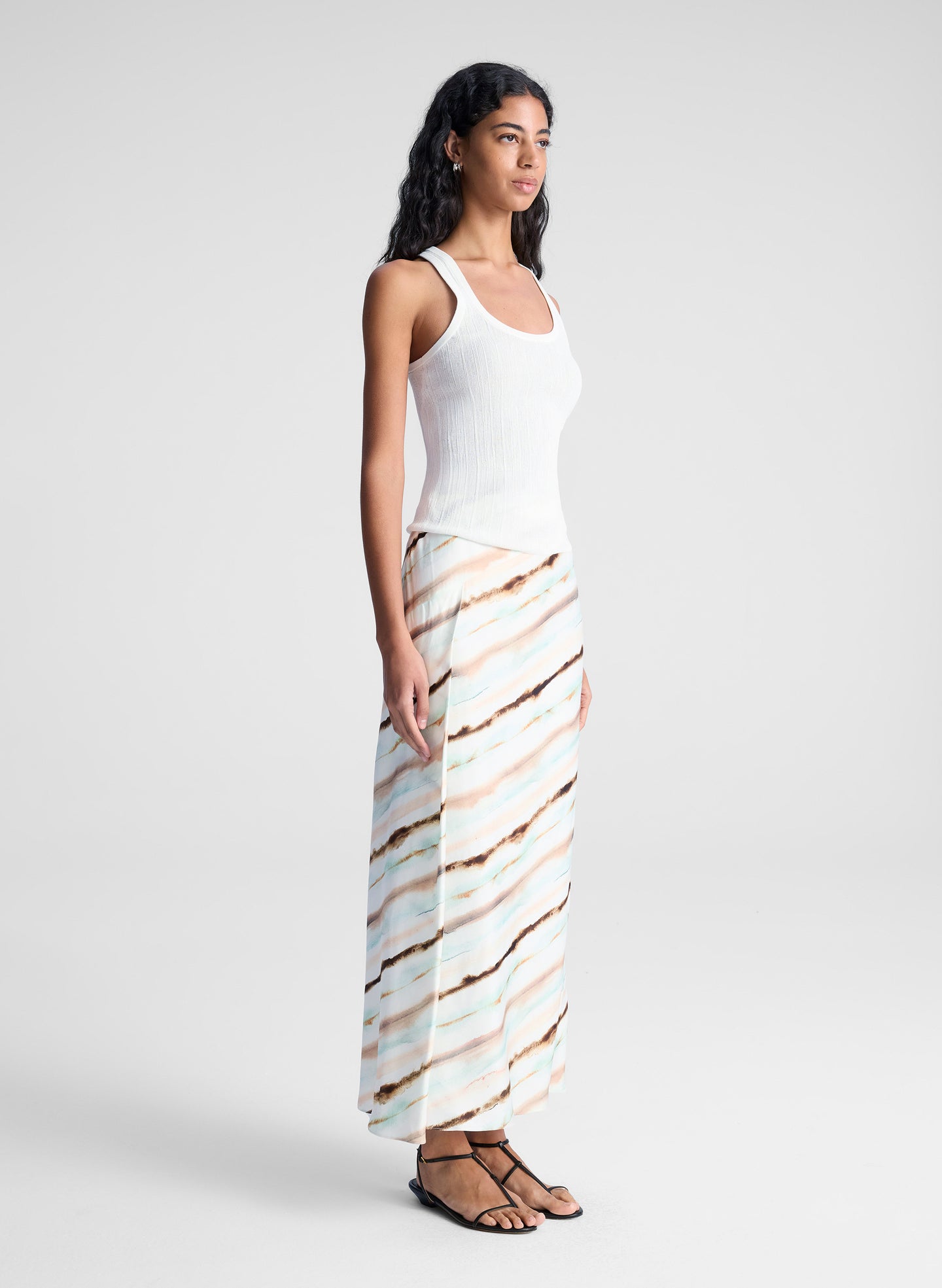 woman wearing white tank top and multicolor striped midi skirt