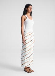 woman wearing white tank top and multicolor striped midi skirt