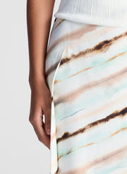 woman wearing white tank top and multicolor striped midi skirt