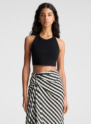 woman wearing black tank top and black and tan gingham skirt