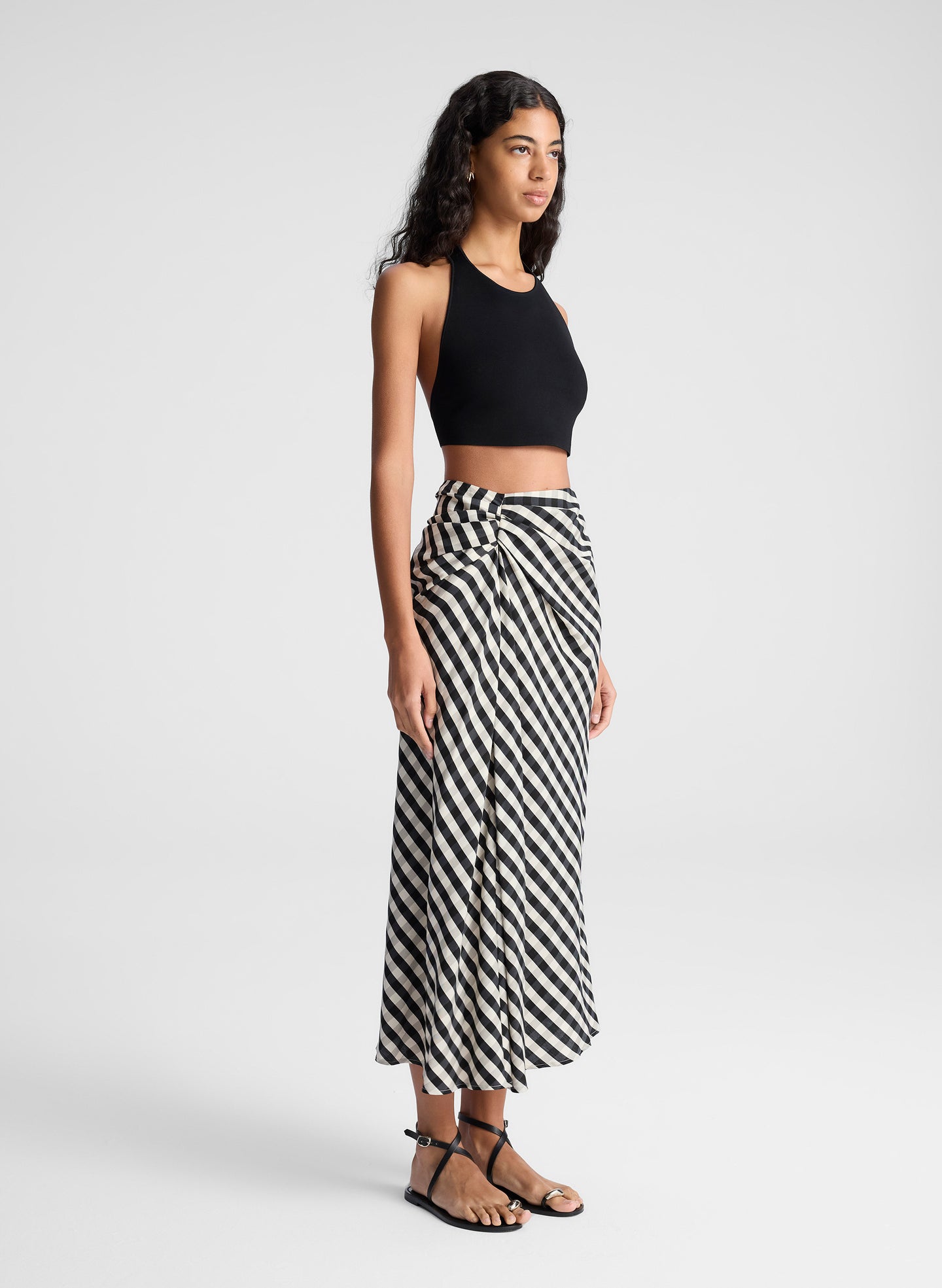 woman wearing black tank top and black and tan gingham skirt