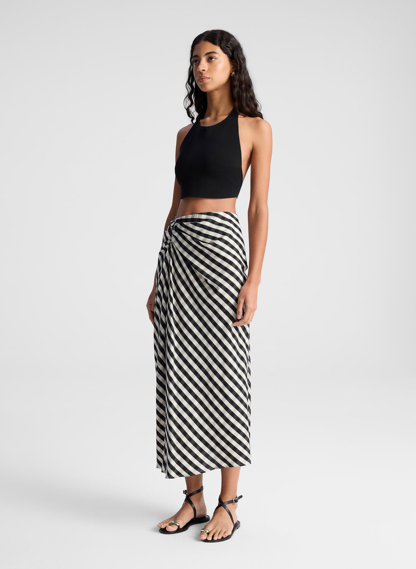 woman wearing black tank top and black and tan gingham skirt