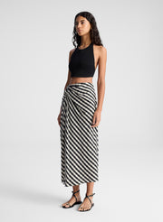 woman wearing black tank top and black and tan gingham skirt