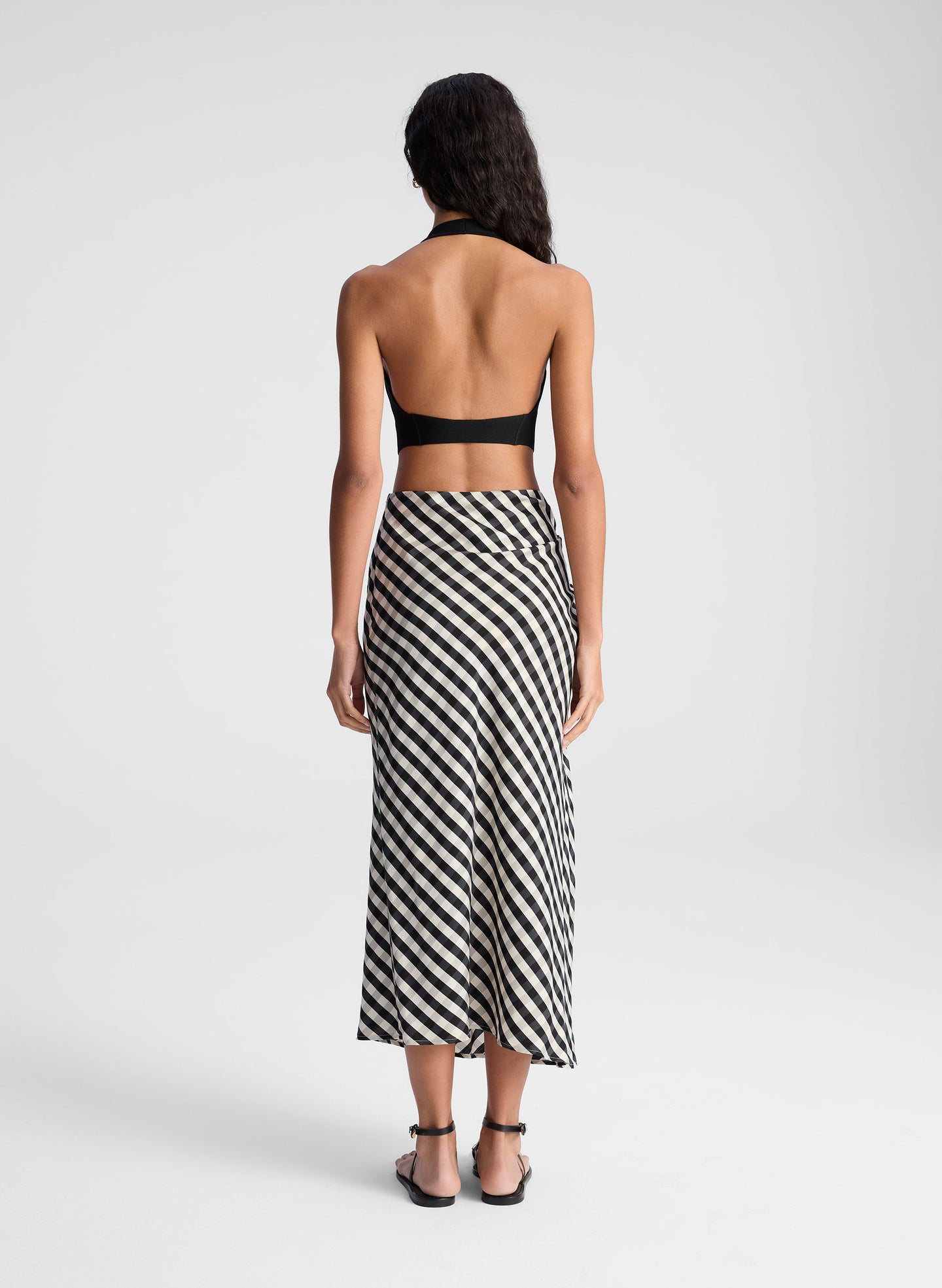 woman wearing black tank top and black and tan gingham skirt