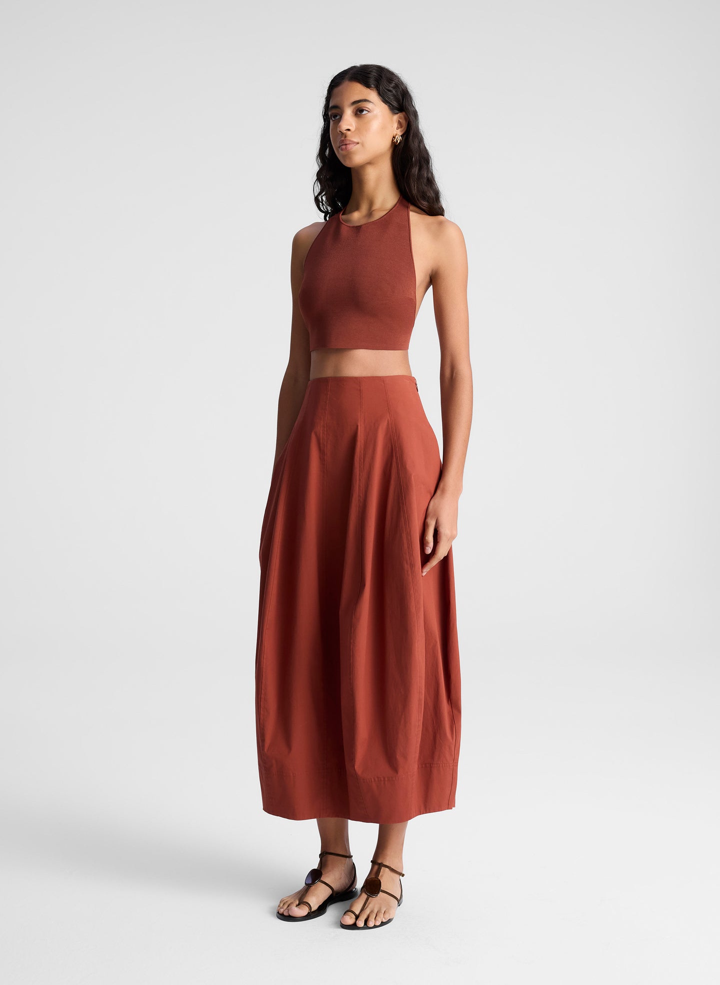 woman wearing maroon knit halter top and maroon midi skirt
