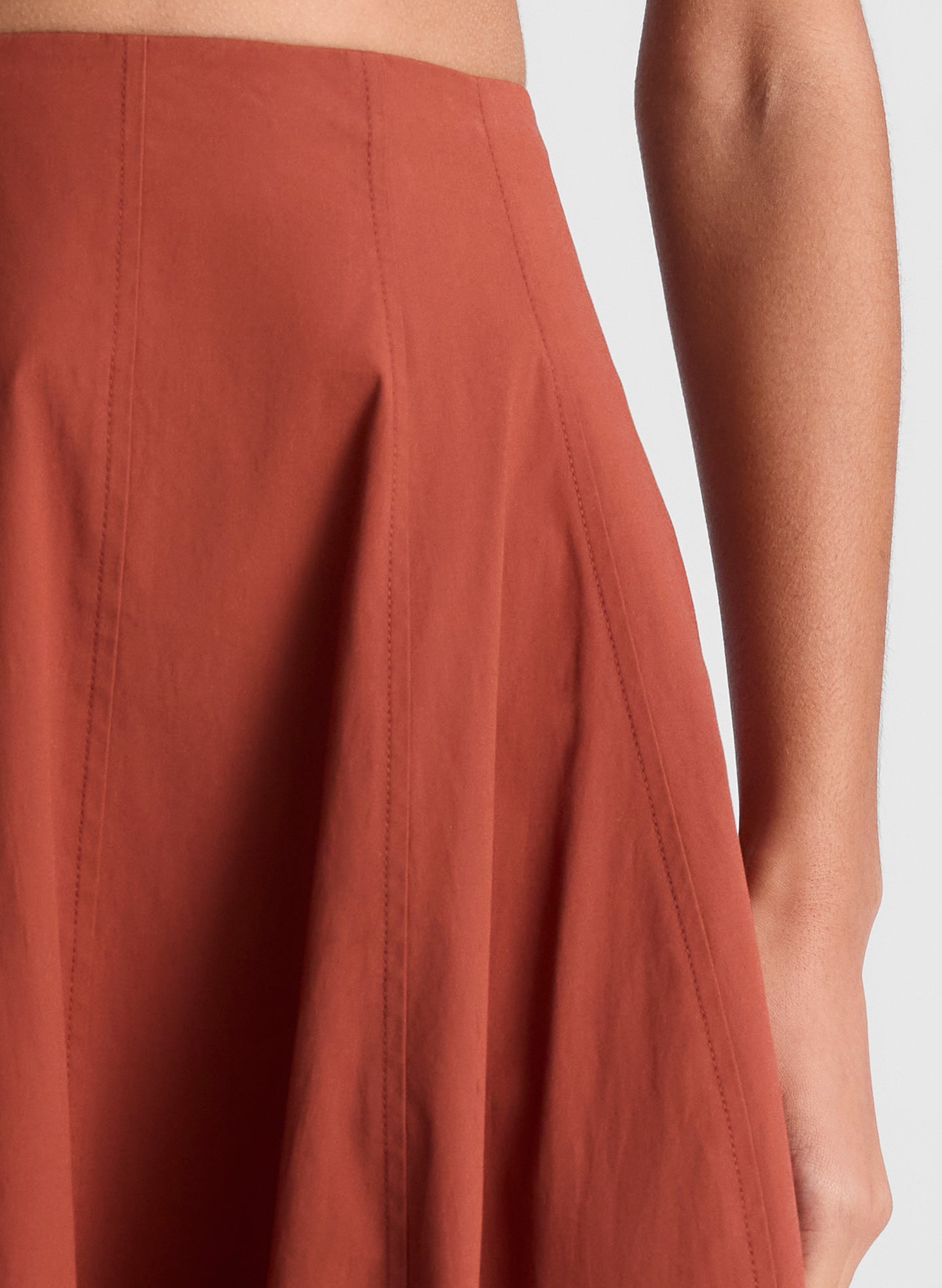 woman wearing brown cropped tank and maroon midi skirt