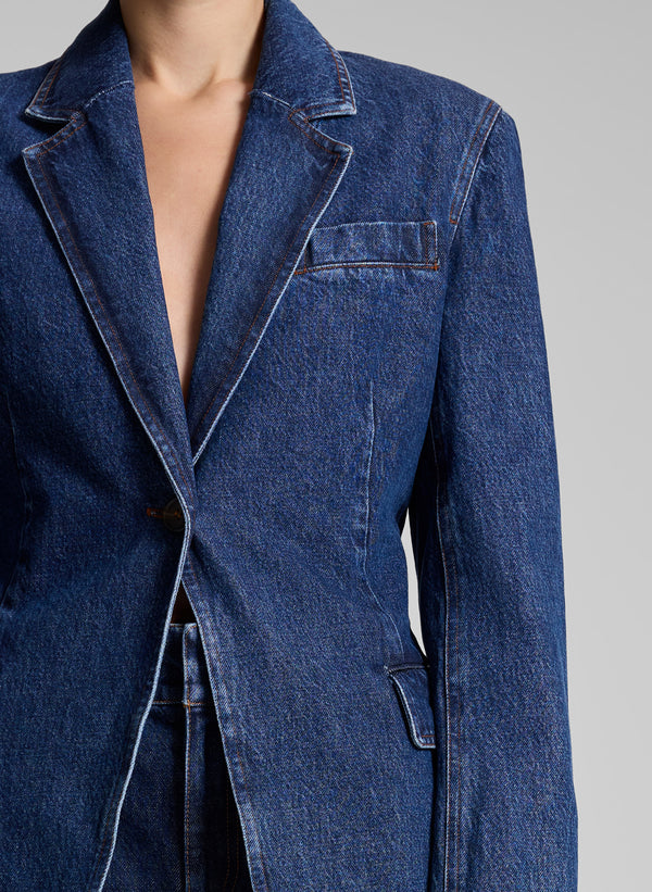 woman wearing medium wash denim suit