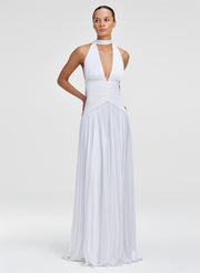 Woman wearing a white halter neck gown on a plain background