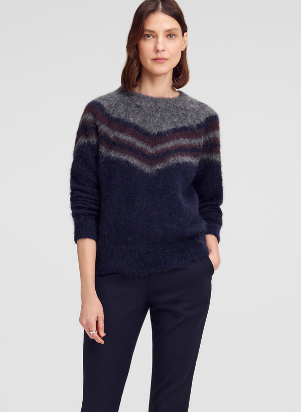 woman wearing chevron striped sweater and blue pants