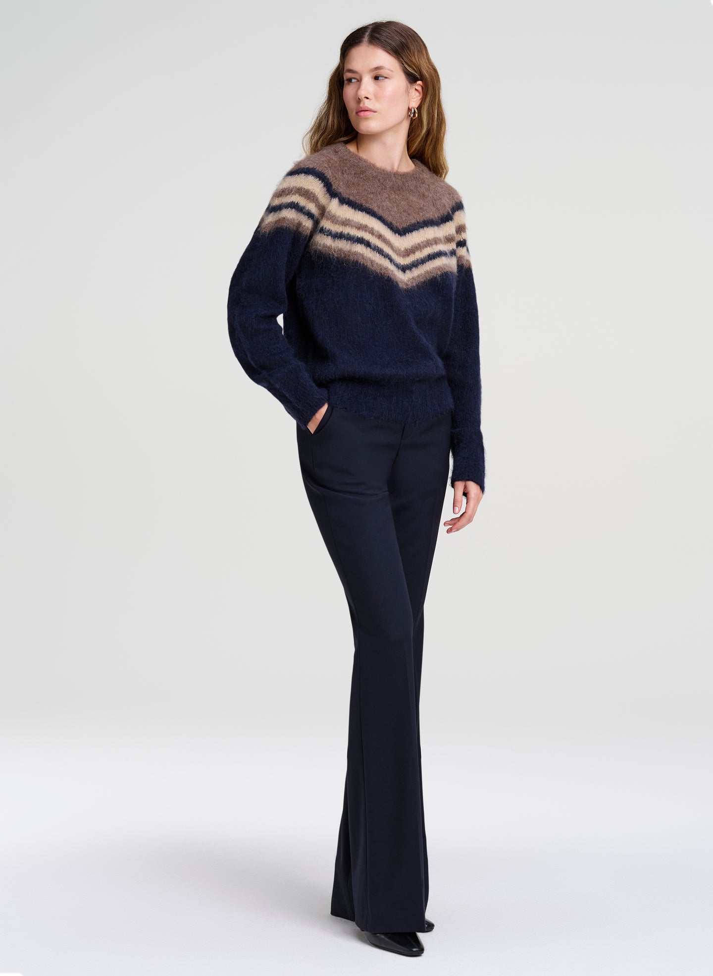 woman wearing brown and navy sweater with navy pants