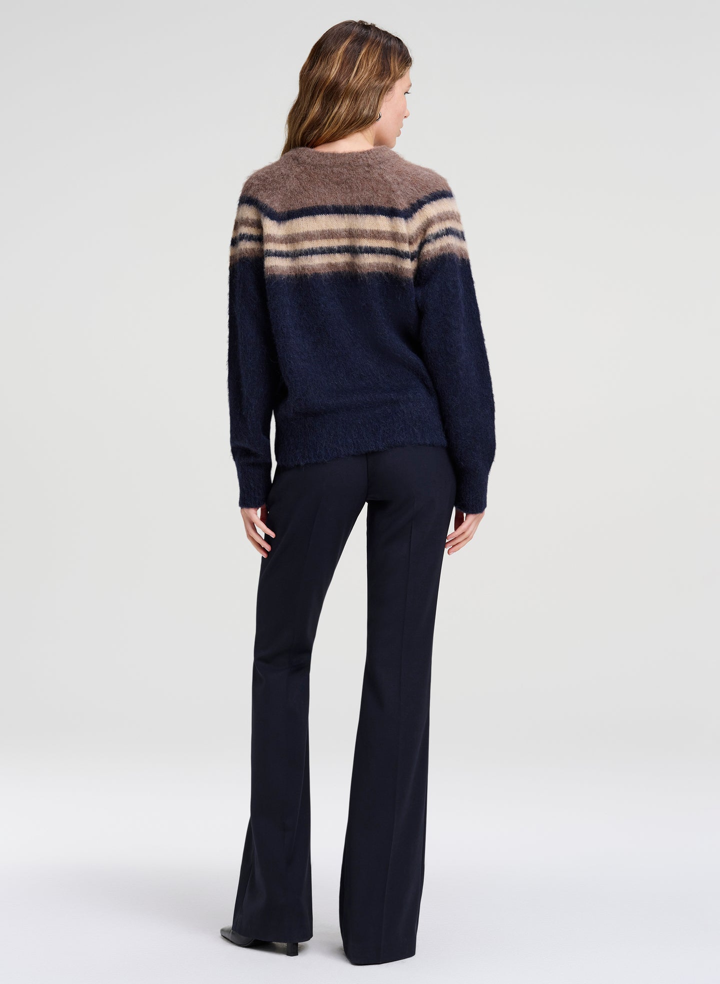 woman wearing brown and navy sweater with navy pants