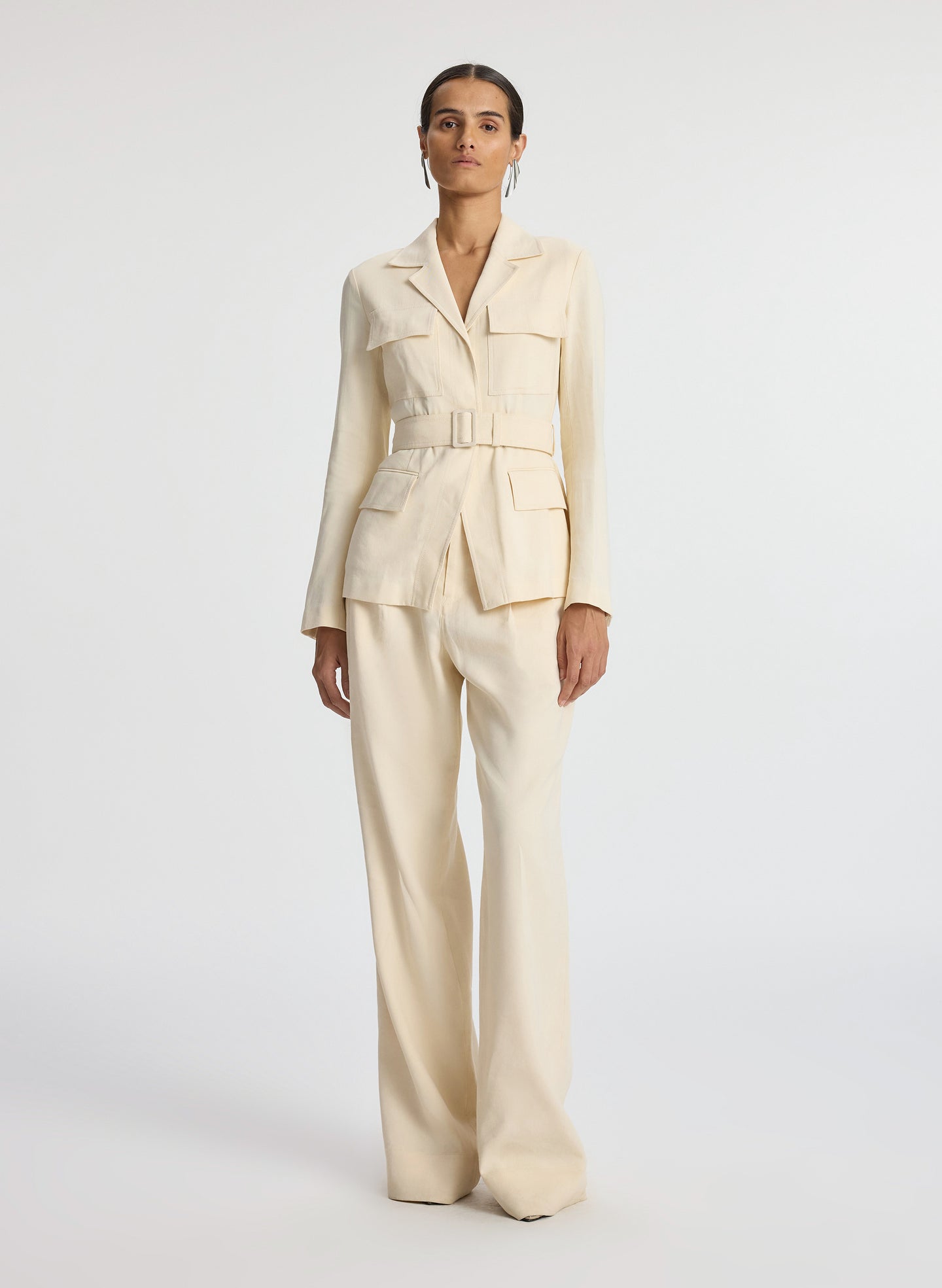 front view of woman wearing beige belted jacket and beige wide leg pants