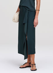 Person wearing a dark green skirt on a white background