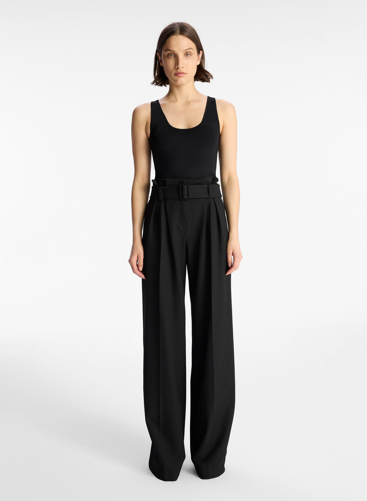 front view of woman wearing black tank top and black wide leg pants