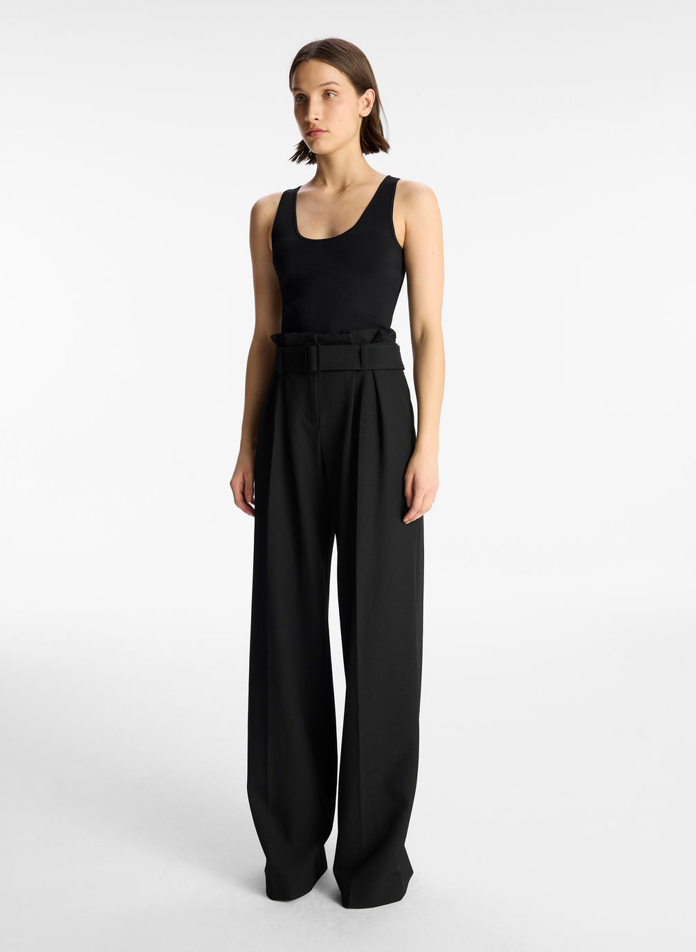 side view of woman wearing black tank top and black wide leg pants