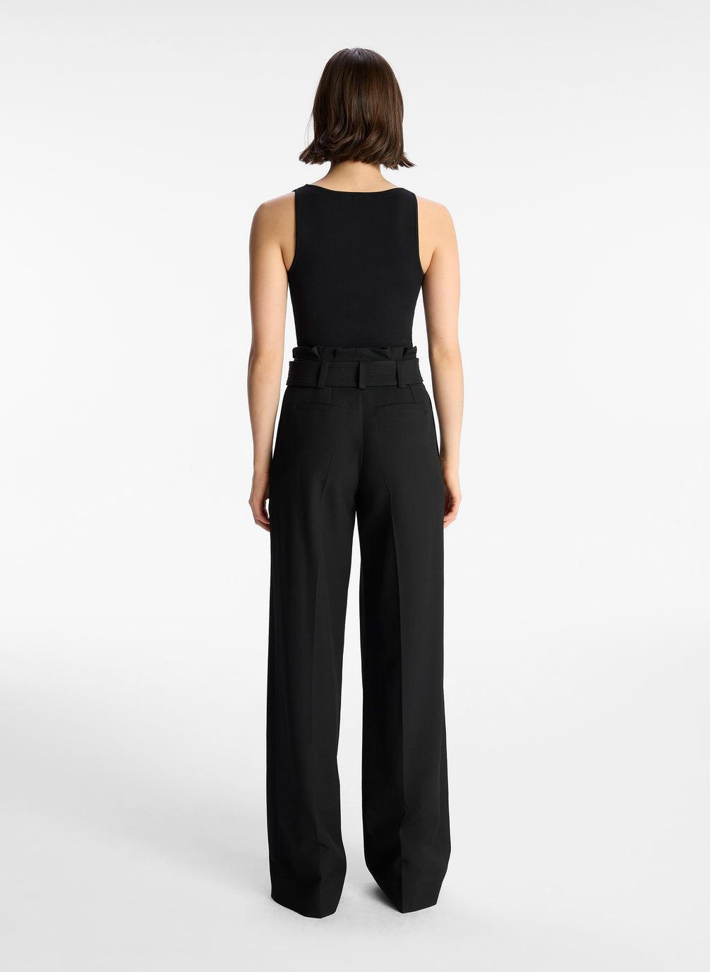 back view of woman wearing black tank top and black wide leg pants