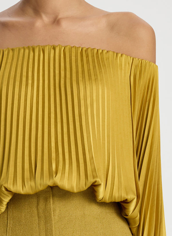 detail view of woman wearing yellow pleated off shoulder top and yellow shorts