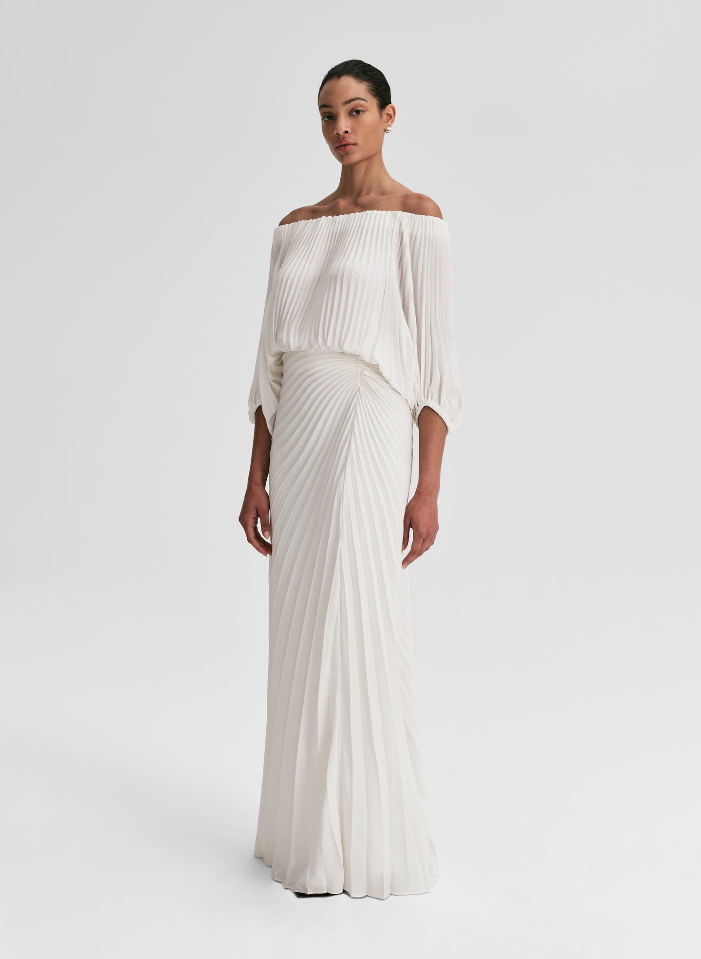 woman wearing white pleated top and matching set white pleated maxi skirt