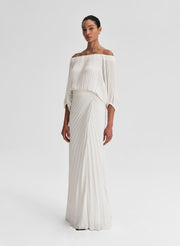 woman wearing white pleated top and matching set white pleated maxi skirt