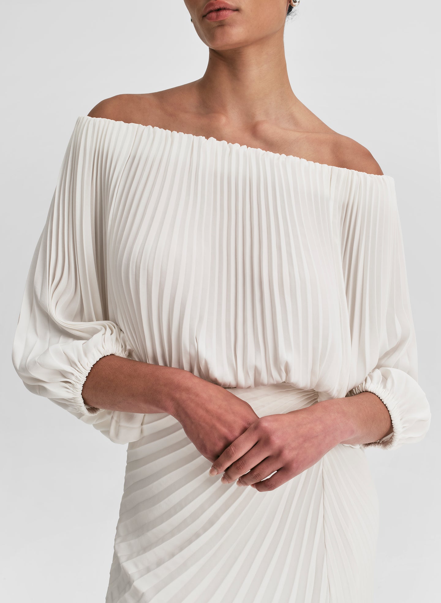 woman wearing white pleated top and matching set white pleated maxi skirt