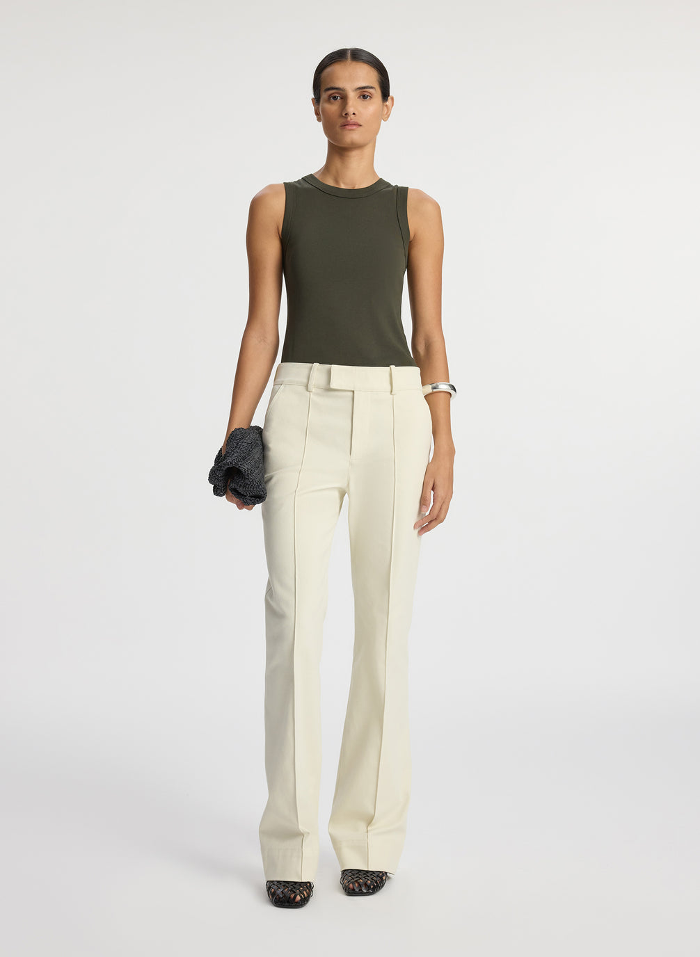 front view of woman wearing olive green sleeveless top with cream wide leg pants