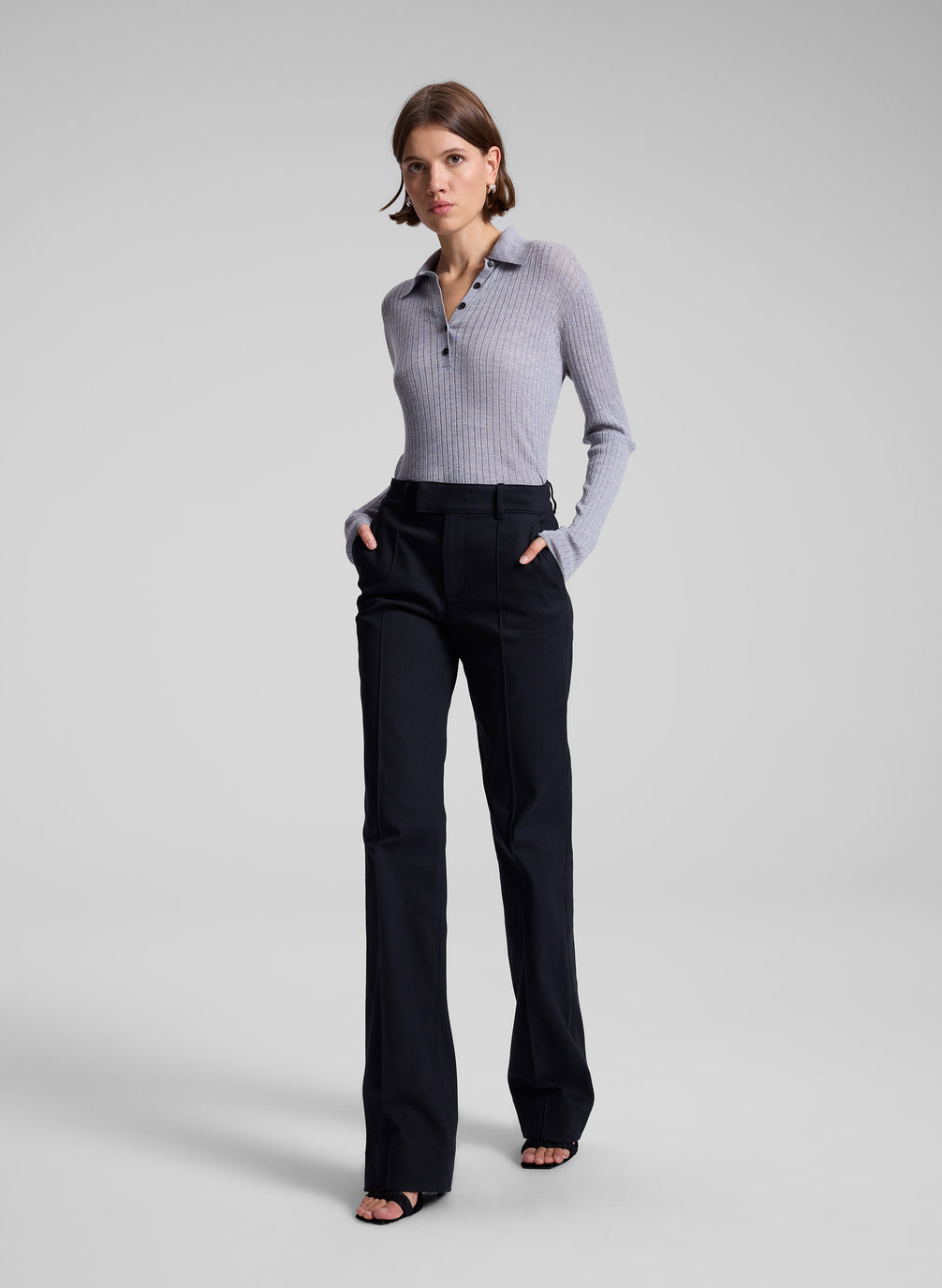 woman wearing navy blue pants and grey knit top