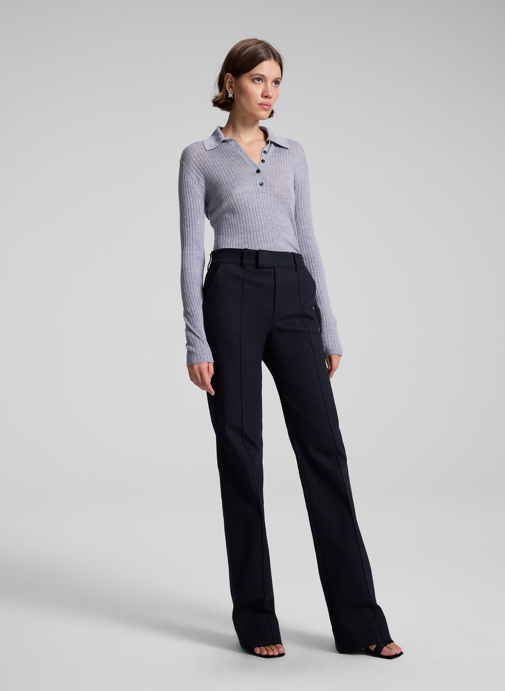 woman wearing navy blue pants and grey knit top