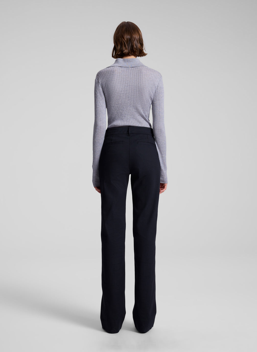 woman wearing navy blue pants and grey knit top