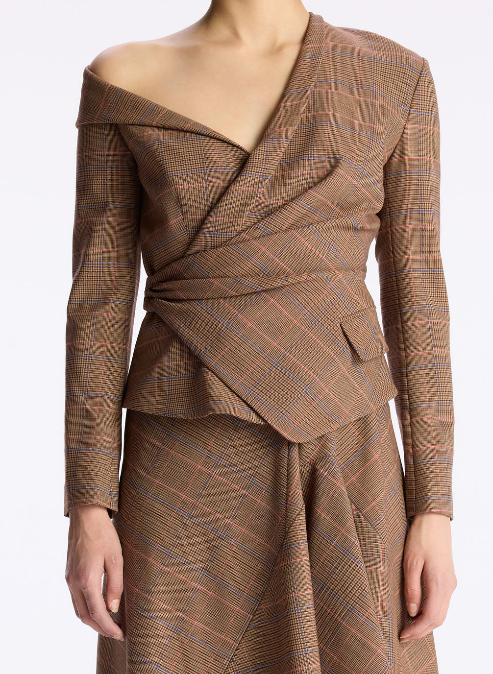 detail view of woman wearing brown plaid asymmetric long sleeve top and matching brown plaid midi skirt