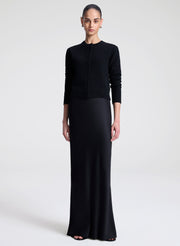 Woman wearing a black cardigan against a white background