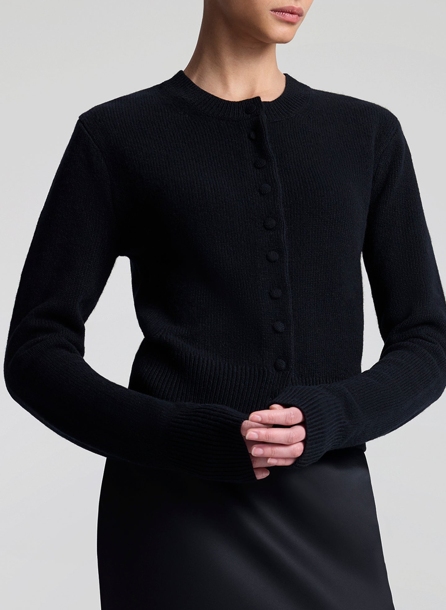 Woman wearing a black cardigan against a white background