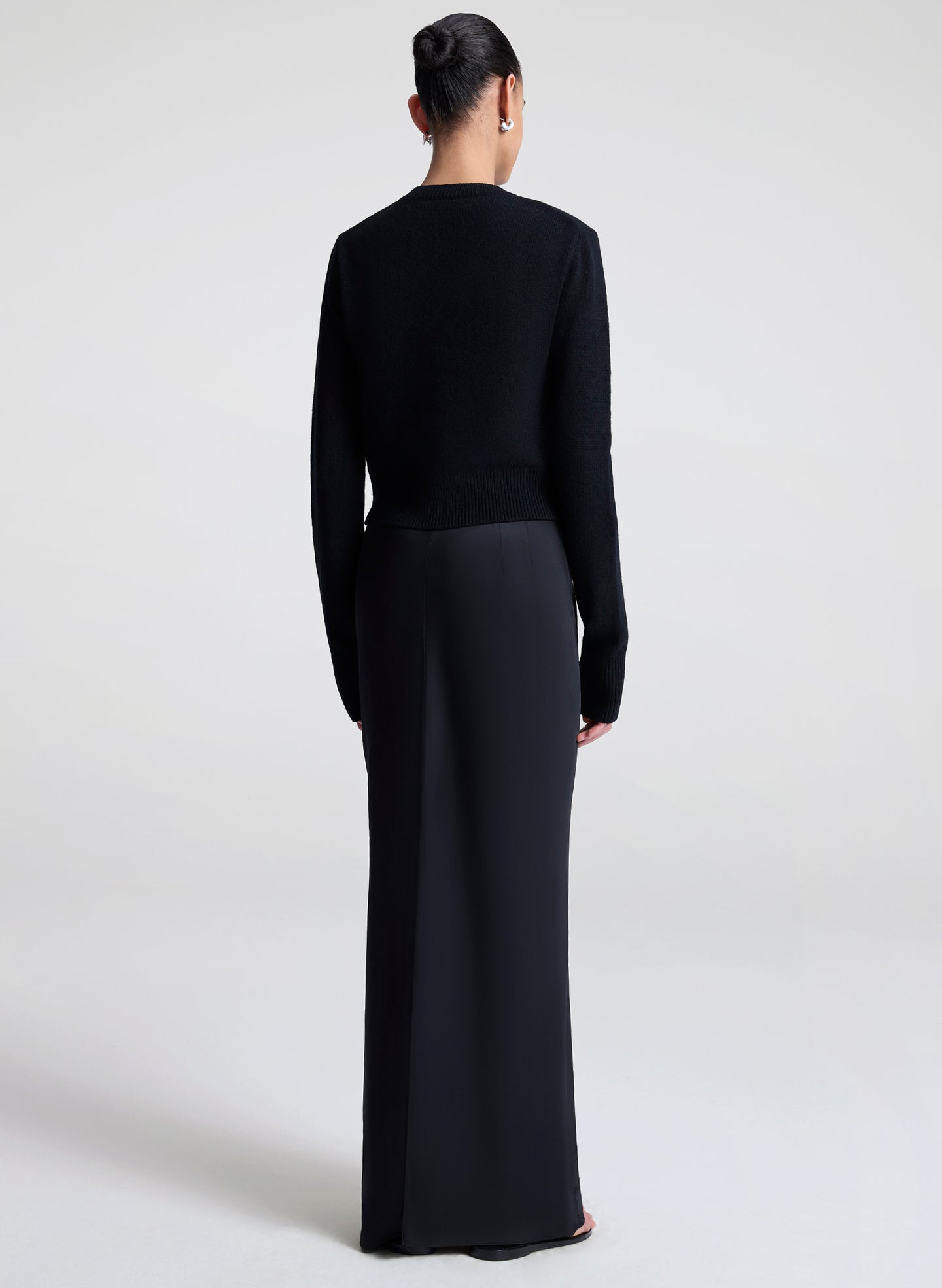 Woman wearing a black cardigan against a white background