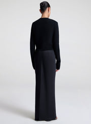 Woman wearing a black cardigan against a white background