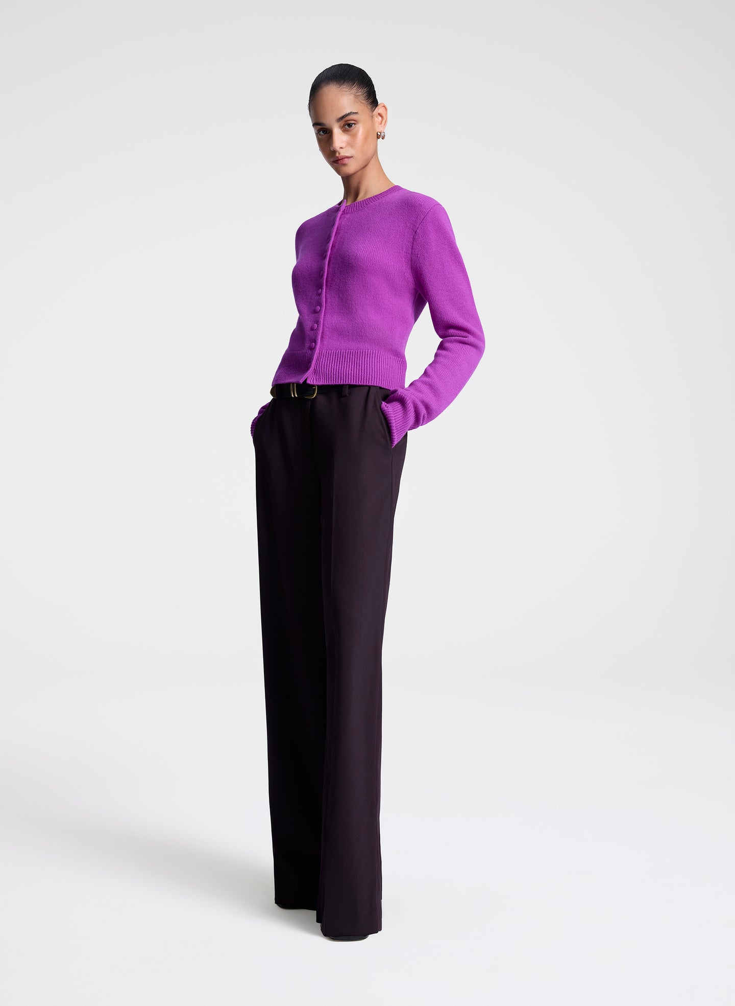 Person wearing a purple sweater and purple pants on a white background
