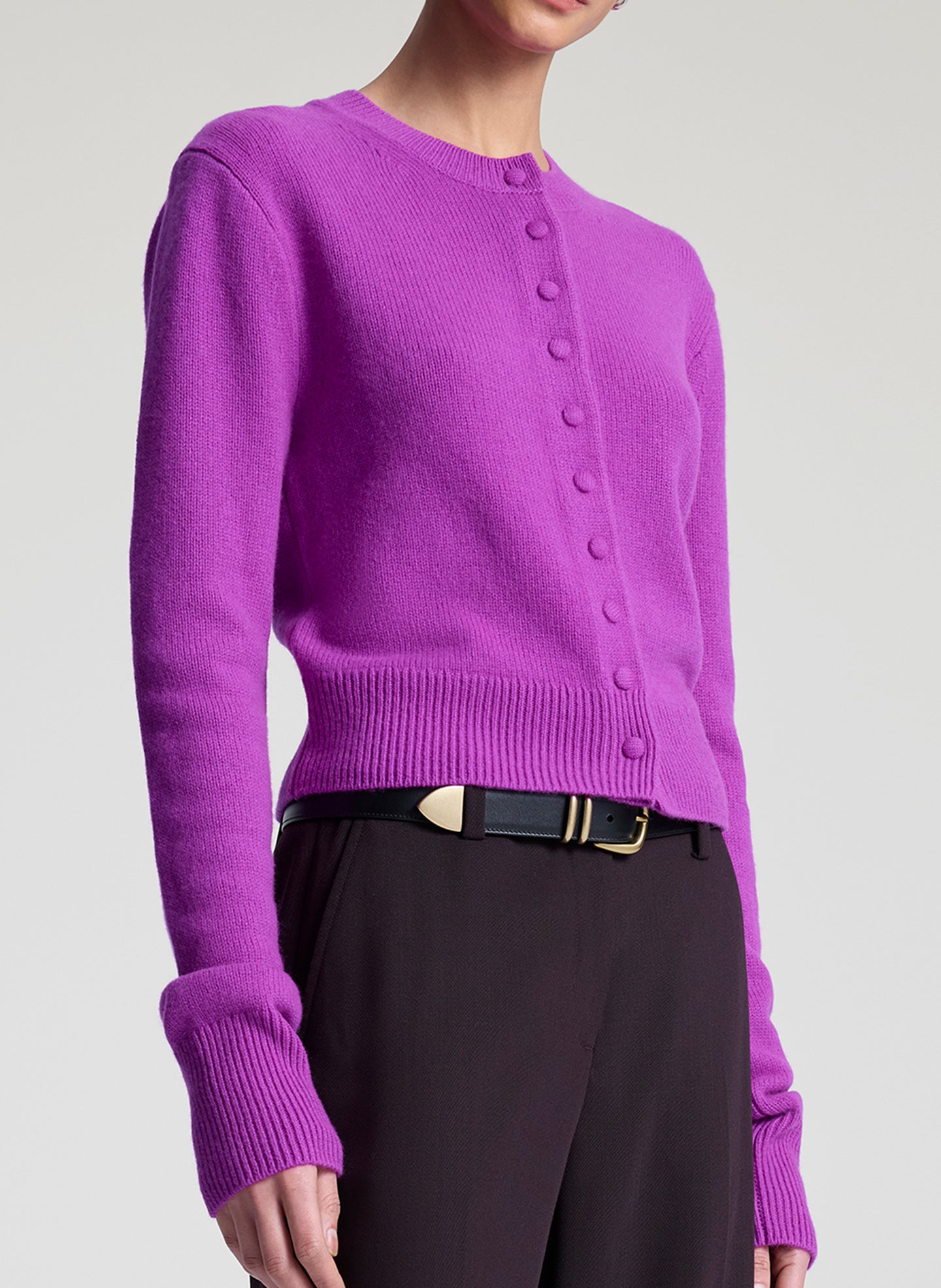 Purple button-up sweater worn by a person on a light gray background