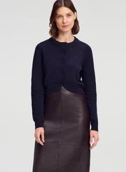 woman wearing navy blue cardigan and brown leather midi skirt