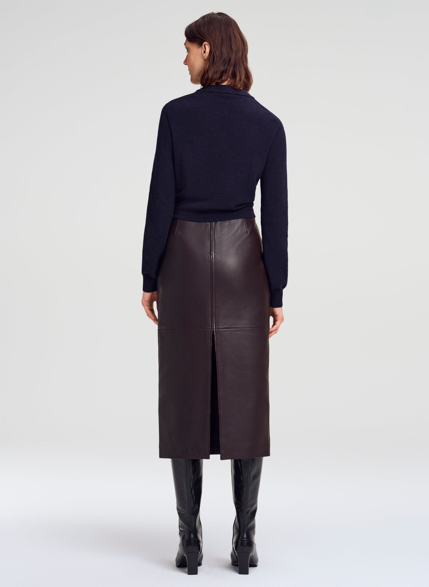 woman wearing navy blue cardigan and brown leather midi skirt with slit