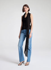 woman wearing dark brown draped top and  light blue denim straight leg jeans