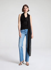 woman wearing dark brown draped top and  light blue denim straight leg jeans